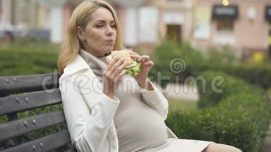美丽期待的女人吃汉堡，坐凳，摸肚，胃口