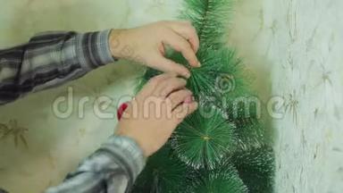男人`手用喜庆的球装饰圣诞树