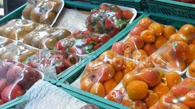在街道市场柜台上，用特殊玻璃纸布保护桃子、尼达林、杏子、草莓、猕猴桃不受污染