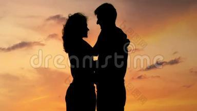 快乐的情侣在日落时拥抱和亲吻，恋爱故事