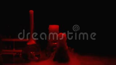 烧瓶中的化学物质在红灯下冒泡和散发烟雾，实验室