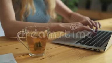 一个<strong>女人</strong>用热水把茶袋浸入杯子里的特写镜头。 年轻的<strong>女人喝茶</strong>。 紧紧抓住女孩`手