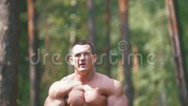 充气男子在夏季森林里锻炼-巨大的二头肌