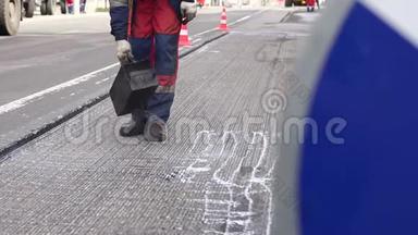 修路。 工作细节，工人浇筑树脂路面覆盖沥青..