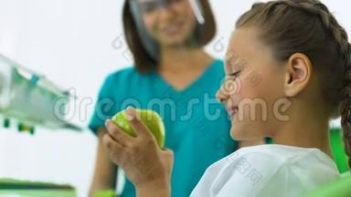 儿童牙医把<strong>苹果送</strong>给女孩，小病人高兴地吃水果