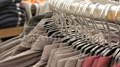 在购物中心的<strong>男装</strong>商店里，一排排各种时尚`男士衬衫在一个巨大的衣架上。