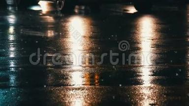 汽车在交通，前灯在雨中的沥青，视图下面。 晚上雨打水坑。 汽车`灯光的反射
