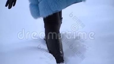 女孩走在白雪皑皑的冬林里。 腿部特写。 深雪中的靴子。 在雪地里台阶。 慢动作。