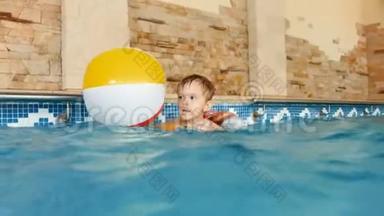 4k镜头快乐微笑的小男孩在游<strong>泳池</strong>玩充气彩色<strong>沙滩</strong>球