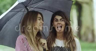 雨天的女士们在雨伞下直视镜头，做着滑稽的脸。