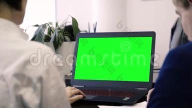 查看员工和绿色<strong>笔记本</strong>电脑屏幕。 从后面的办公室工作人员的<strong>笔记本</strong>电脑与绿色屏幕。 概念