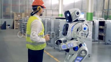 一个男人在工厂和机器人说话