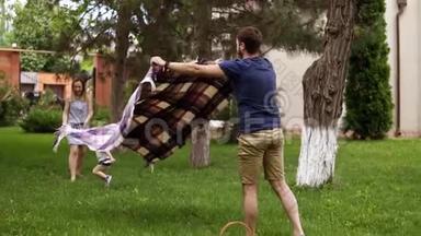 白种人家庭户外。 父亲，母亲和金发的小儿子。 爸爸铺了一个<strong>野餐</strong>套，<strong>野餐</strong>篮子。 草坪