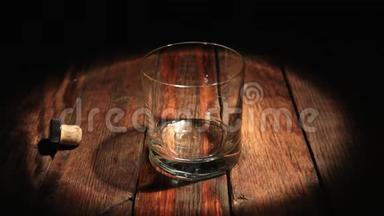 在光线下的黑色背景上从瓶子里倒入<strong>威士忌</strong>。 一杯朗姆酒。