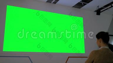 女人看着大片空白的绿色屏幕-电影模拟