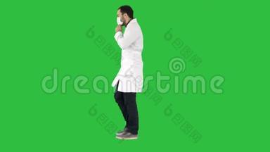 步行医生把医疗面罩放在绿色屏幕上，铬键。