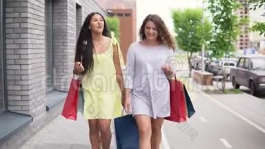 两个漂亮的女孩走在街上，购物后手里拿着包裹，心情很好。 4K