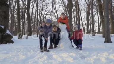 冬天公园里，四个穿着紧身衣的男孩在堆雪人的时候
