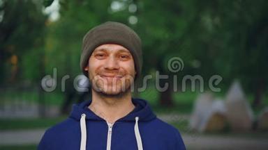 特写慢镜头肖像快乐运动员微笑着看着镜头站在公园春天。 积极主动