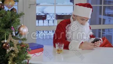 穿着圣诞老人服装的年轻人坐在桌子上，在他的留言