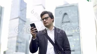 一位戴着眼镜的商人在莫斯科的智能手机屏幕上