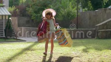 购物之旅，时尚的戴墨镜和帽子的小女孩购物者在参观商店后用袋子购物