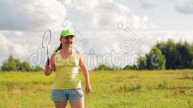 一个在空地上打羽毛球的女人发球和击球