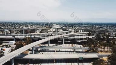 无人机在<strong>美国洛杉矶</strong>的大型公路立交桥上向后飞行，交通通过许多道路水平。