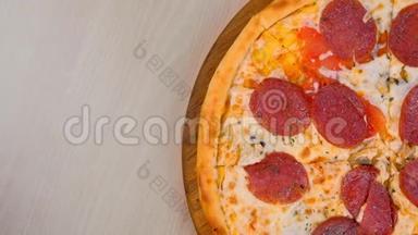 一半的意大利腊肠披萨放在桌上的木板上。 特写俯视图..