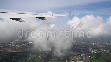 飞机在城市上空的云层中飞行，飞机机翼紧贴地面