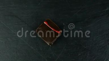 黑色餐桌上小方块巧克力糖果的慢全景