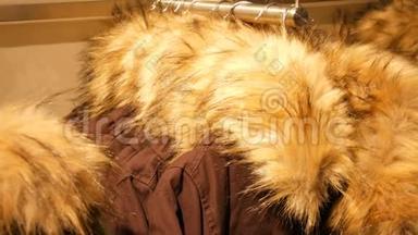 时尚温<strong>暖</strong>的冬季夹克，毛皮领子挂在一家商<strong>场</strong>的服装店的衣架上。