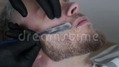 胡子是用剃刀刮的. 在理发店里把剃胡须收起来。 男式胡须。 刮胡子的理发师