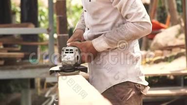 修理人用砂光机加工木板。 木工用轨道砂光机抛光木表面。 工人