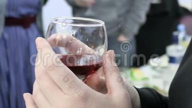 女人拿着一杯红酒。 在这次活动中，人们把杯子和饮料粘在一起。 4K，超高清，超高清
