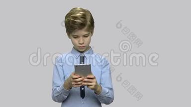 小男孩在智能手机上上网。