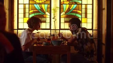 两个人坐在咖啡馆的桌子旁，聊天<strong>吃东西</strong>
