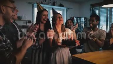快乐的欧洲<strong>女孩</strong>拿着生日蛋糕，<strong>许愿</strong>吹着，多民族朋友在欢乐的聚会上唱着慢动作。