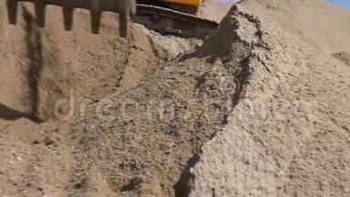 挖掘机正在准备一堆沙子，以便在建筑<strong>工地</strong>的卡<strong>车</strong>上装载