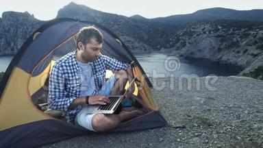 <strong>自由职业者</strong>使用笔记本电脑在海滩露营帐篷工作。 从事新启动项目的<strong>自由职业者</strong>