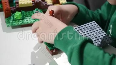 孩子们`手拿着一块乐高积木玩，双手合拢。 乐高是一种流行的建筑玩具