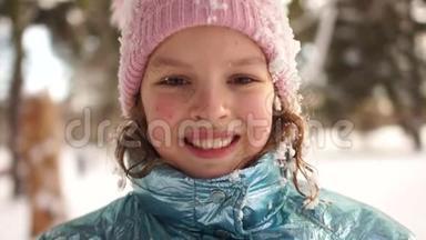 <strong>微</strong>笑的女孩在公园里享受寒冷阳光的早晨。 一个在雪地里玩耍的女学生的肖像画，<strong>粉色</strong>