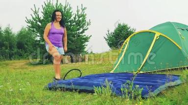 一个女人用水泵用她的脚泵一个充气床垫。