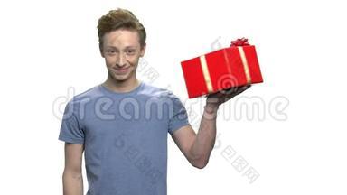 显示红色礼品盒的少年男孩。
