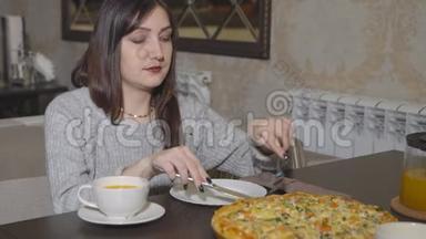披萨饼。 年轻女子拿着一片带餐具的披萨