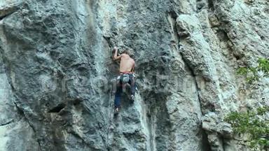 强壮的肌肉男攀岩者在户外运动路线上攀登垂直悬崖