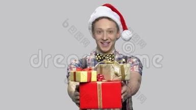 戴圣诞帽的男孩送礼物盒。