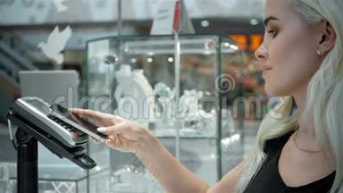 女士金发，时尚模特在超市用手机支付NFC技术