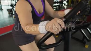 有动力的肥胖妇女在<strong>健身</strong>房的固定自行车上辛勤工作，<strong>减肥</strong>