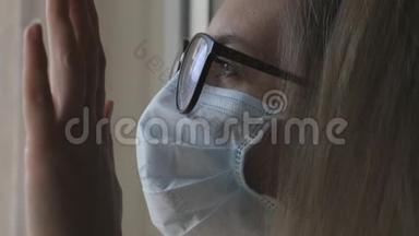 戴着医用<strong>防</strong>护面罩戴<strong>眼镜</strong>的女人正朝窗外看。